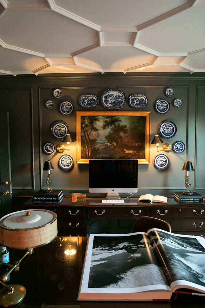 Photo of John's office wall with decorative plates and a framed painting