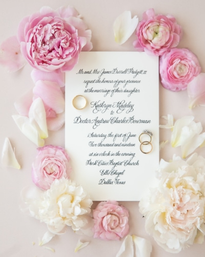 Photo of wedding stationary with rings and roses