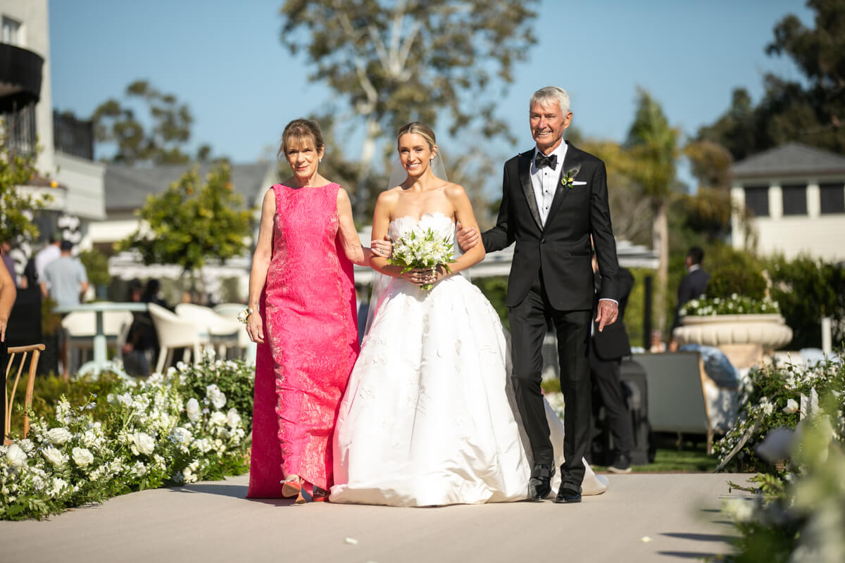 caitlin's mom and dad walking her down the aisle