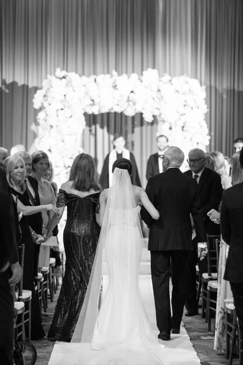 carey's mom and dad walking her down the aisle
