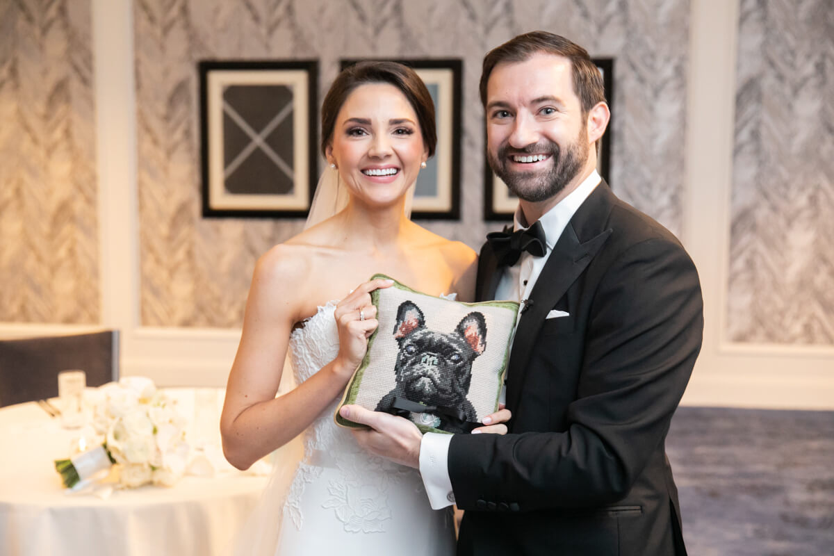 carey and david holding a pillow with a dog on it