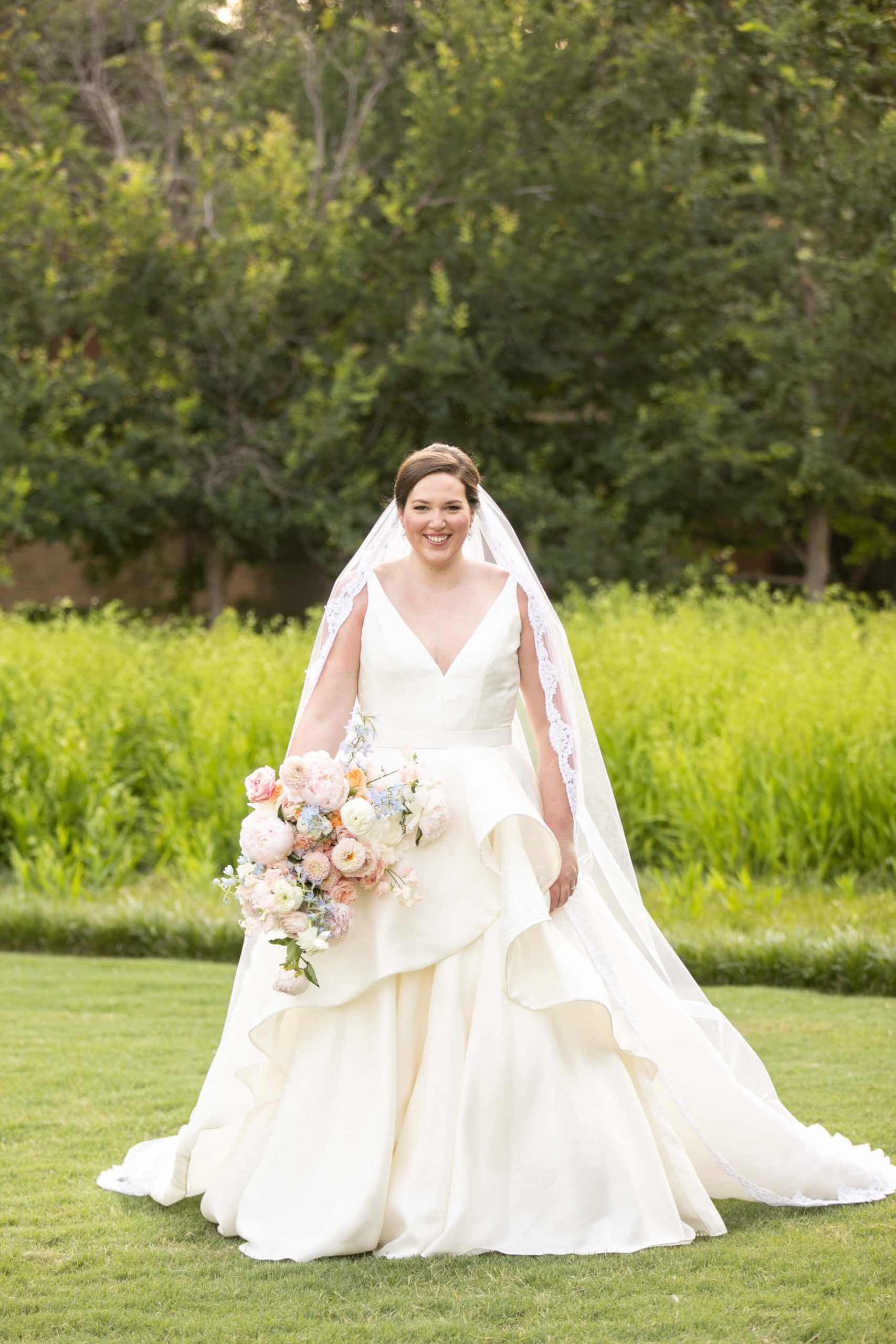 Carole Anne in her bridal gown in a park with bouquet