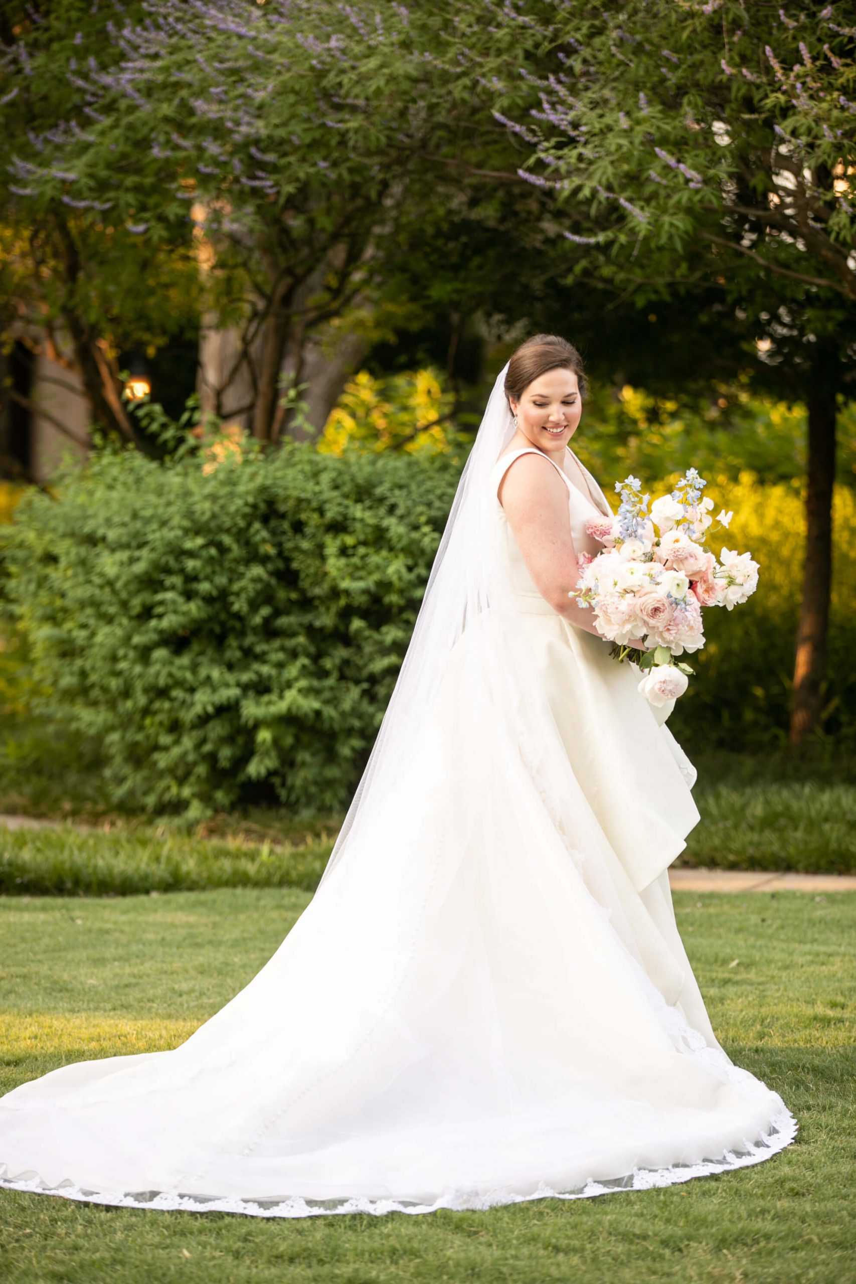 Carole Anne in her bridal gown in a park with bouquet