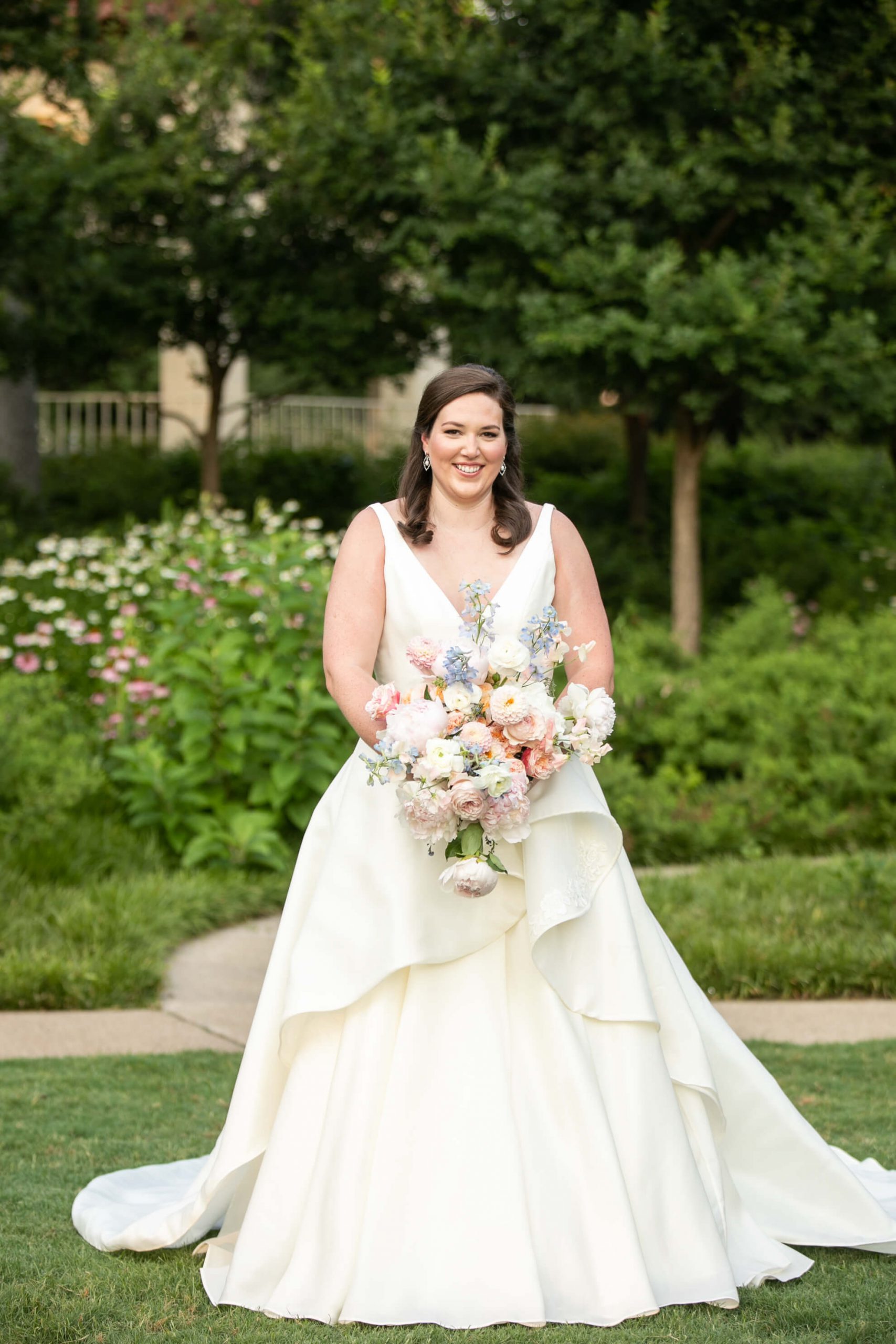 Carole Anne in her bridal gown in a park with bouquet