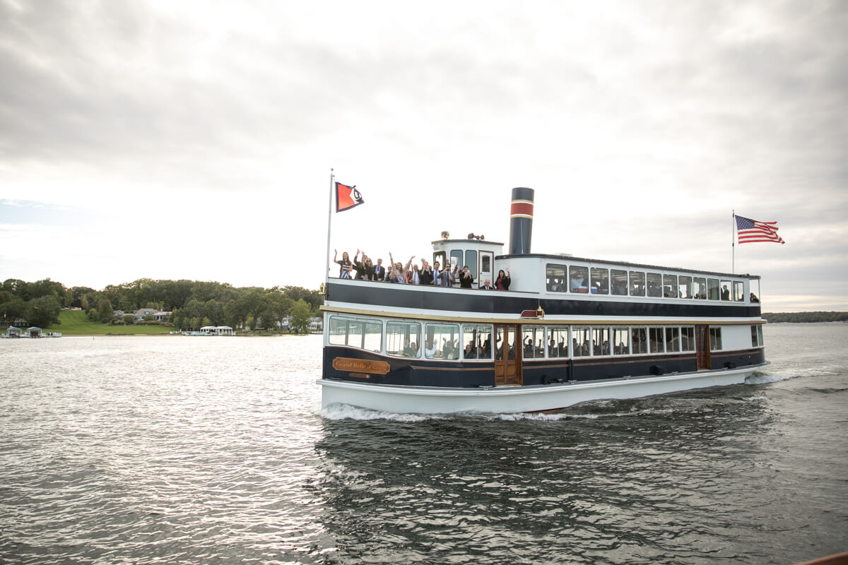 wedding guests waving from boat