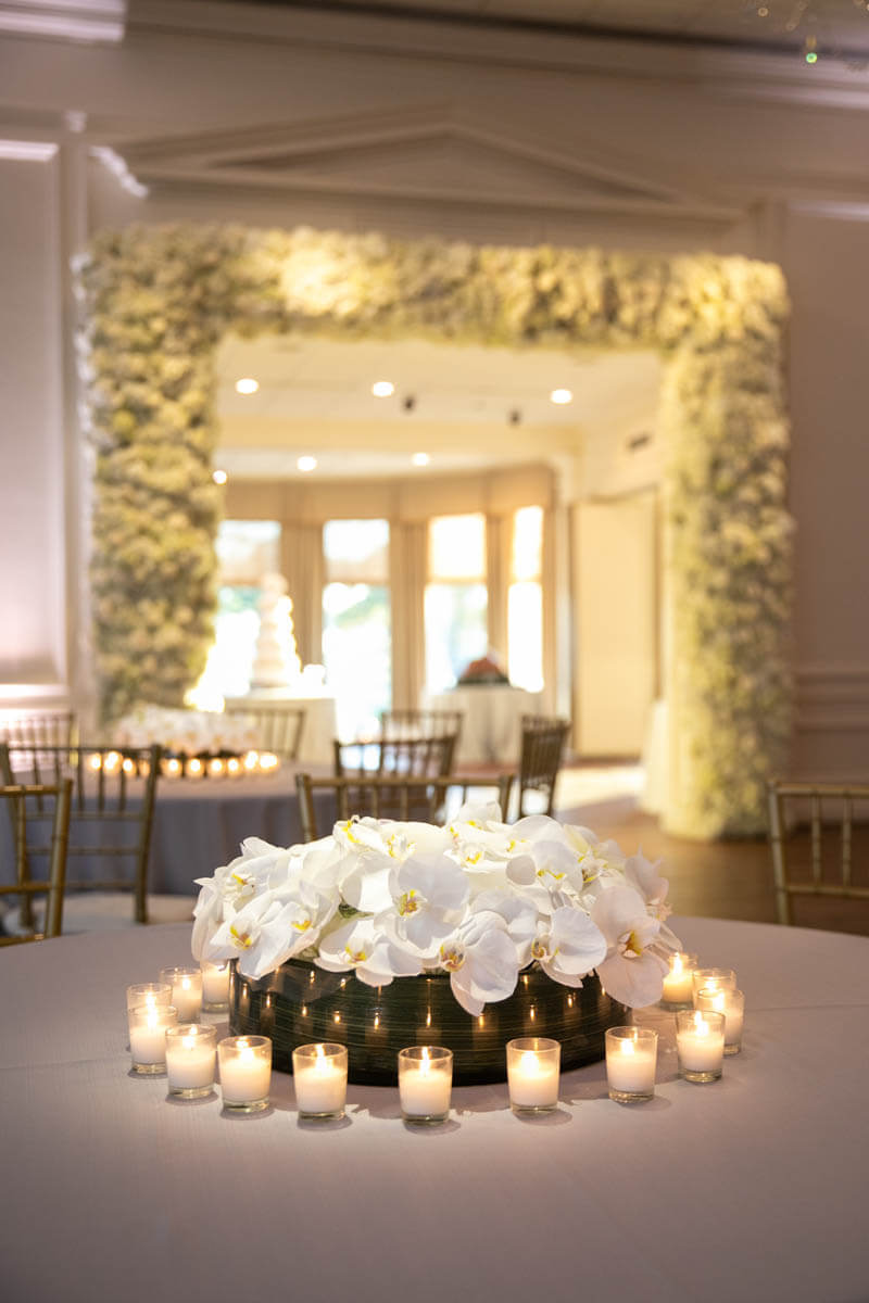 all white floral arrangements and arch